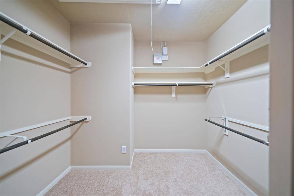 Spacious walk-in master closet with ample shelving.