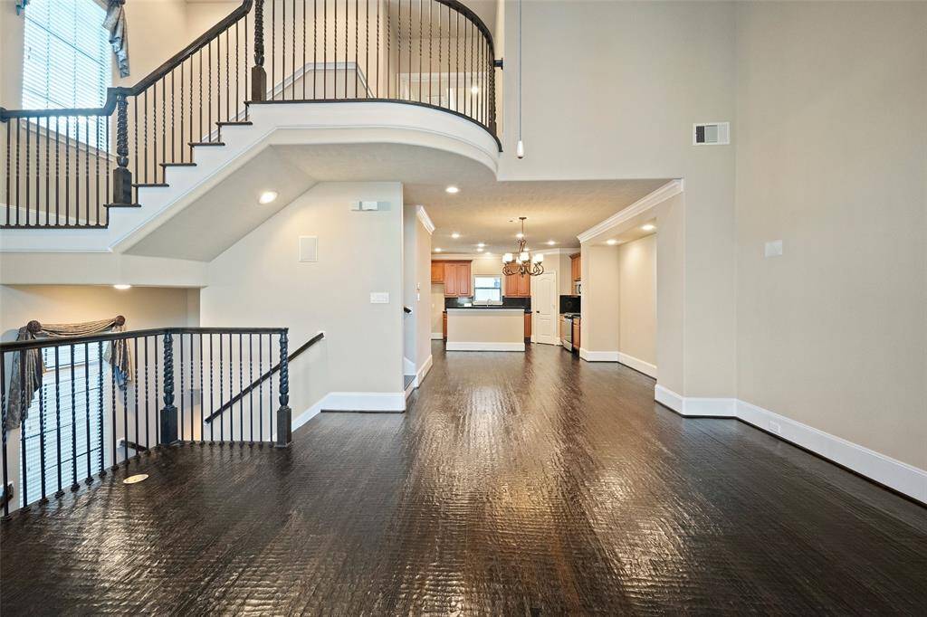 Experience the seamless flow of the open-plan second floor, featuring generous living, dining, and kitchen spaces, elegantly connected by a sweeping staircase to the level below.
