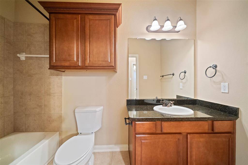 Convenient ground-level full bathroom with elegant granite vanity.