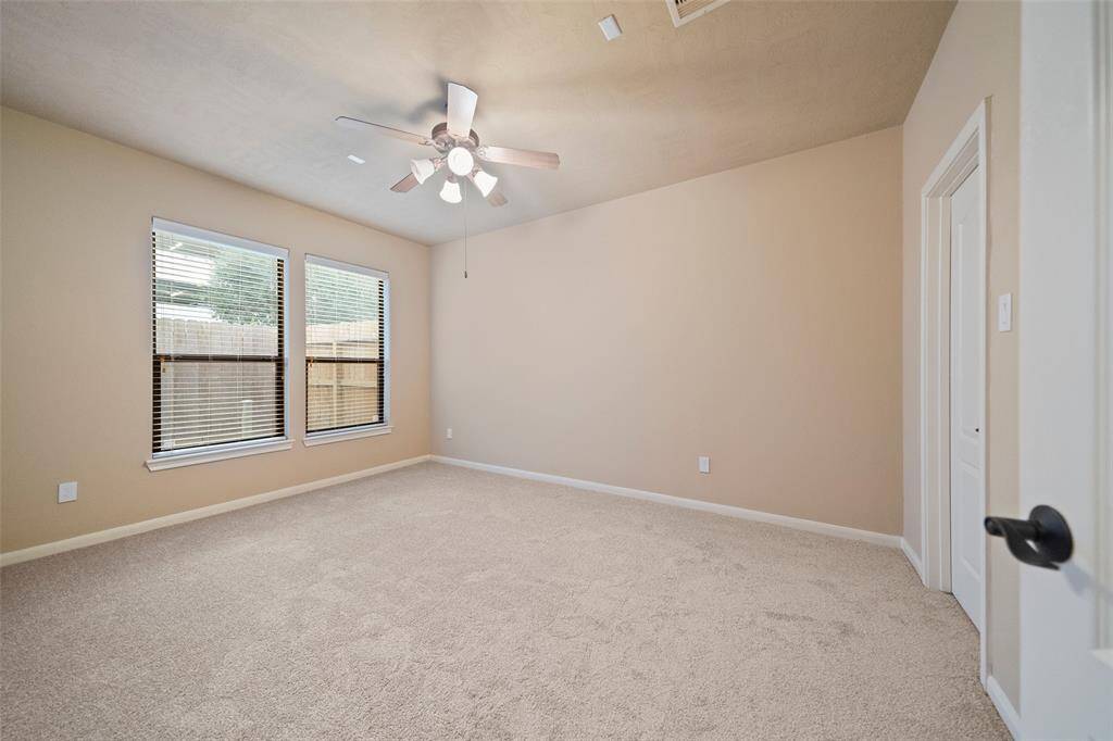 Explore the cozy third bedroom on the ground level, bathed in natural light with plush carpeting and a soothing color palette.