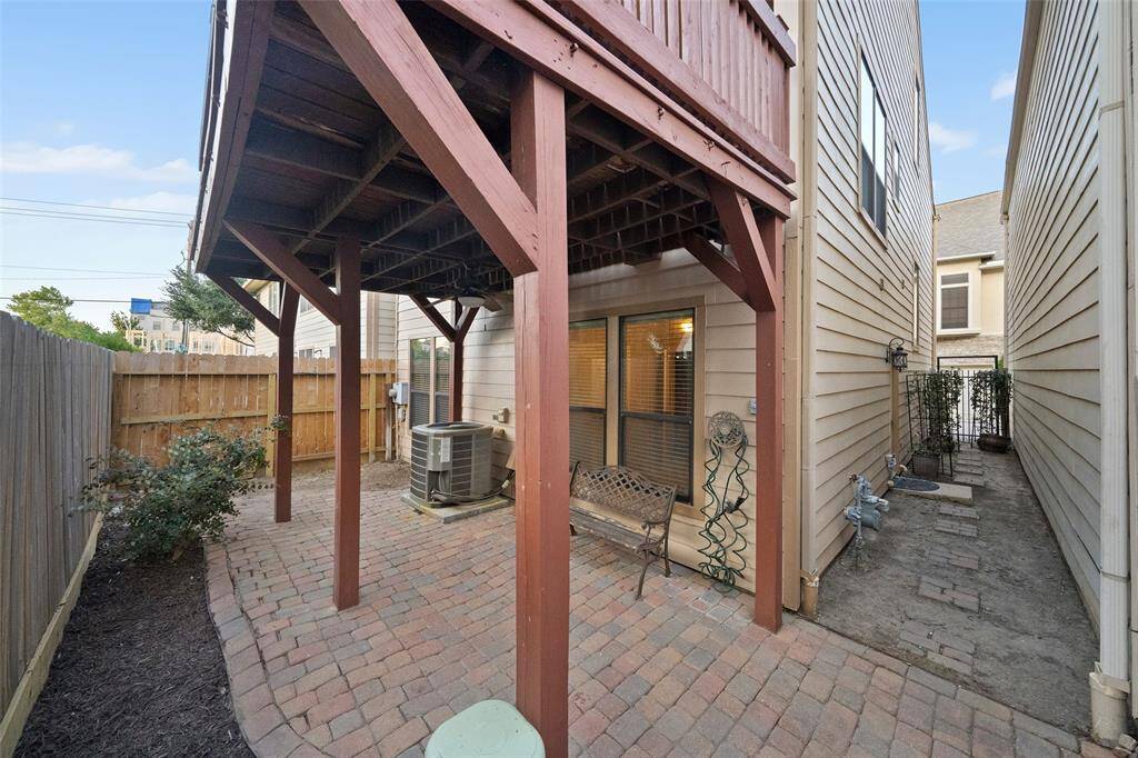 Spacious, semi-covered brick patio with a brand-new wooden privacy fence, installed in 2024.