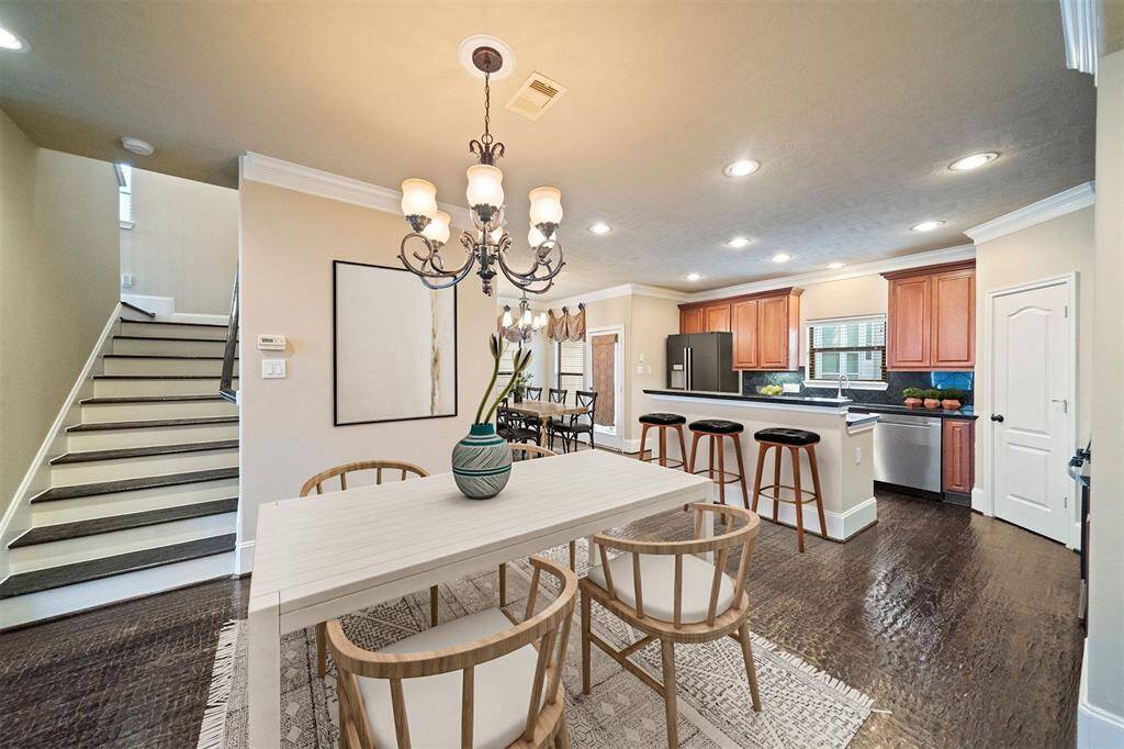 Experience the seamless flow between the inviting dining area and the modern, well-appointed kitchen in this elegantly designed space, enhanced for visual representation.