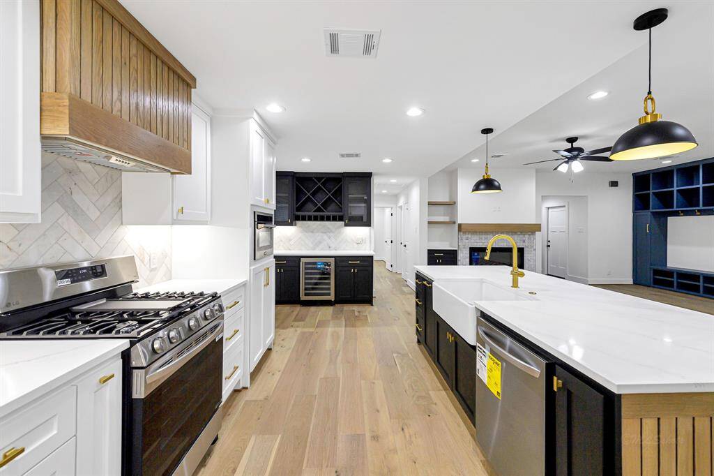 A stunning open kitchen with quartz countertops, a large island, and a sleek gas cooktop.
