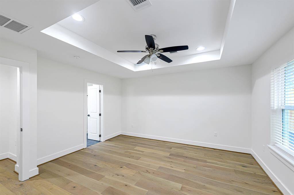 The spacious primary suite offers a peaceful escape with warm white oak flooring and ample natural light.