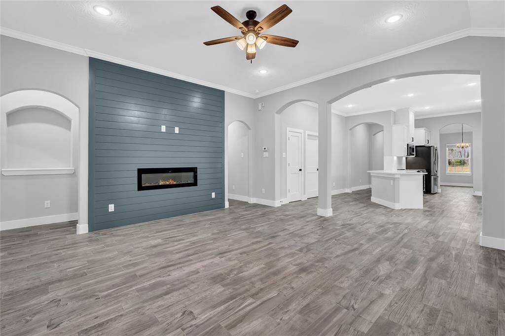 To the right of the fireplace wall is the hallway to the guest bedrooms; to the left of the wall is the entry to the primary bedroom.