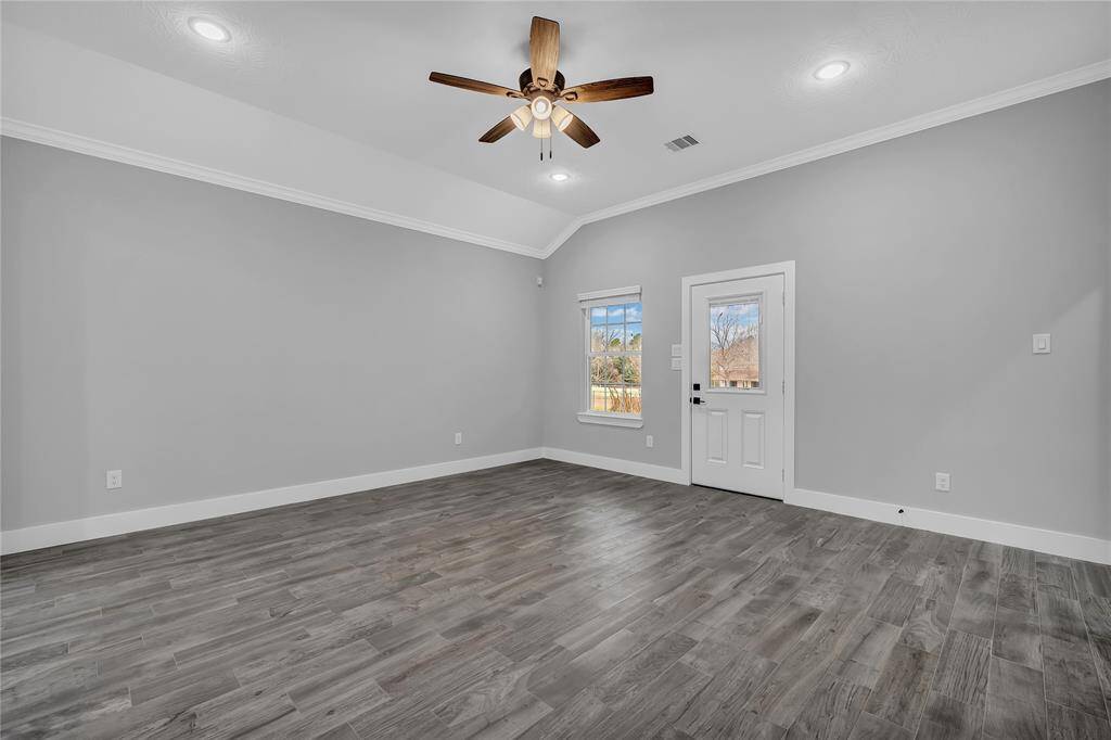 Door in living area leads to covered back porch with ceiling fan.