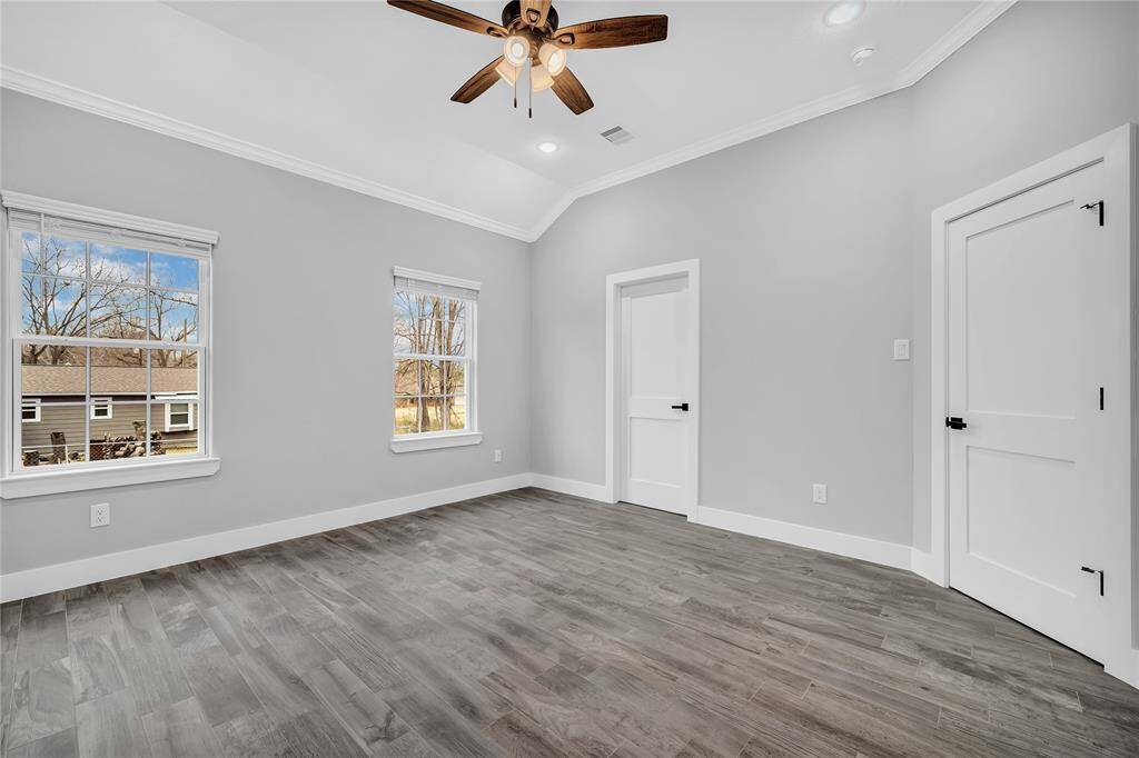 Primary bedroom with high ceilings, crown molding, a large walk in closet and en-suite.