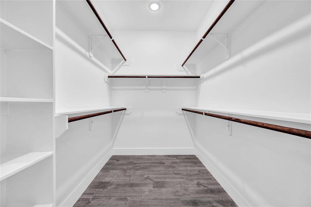 Huge primary walk in closet with shelving.
