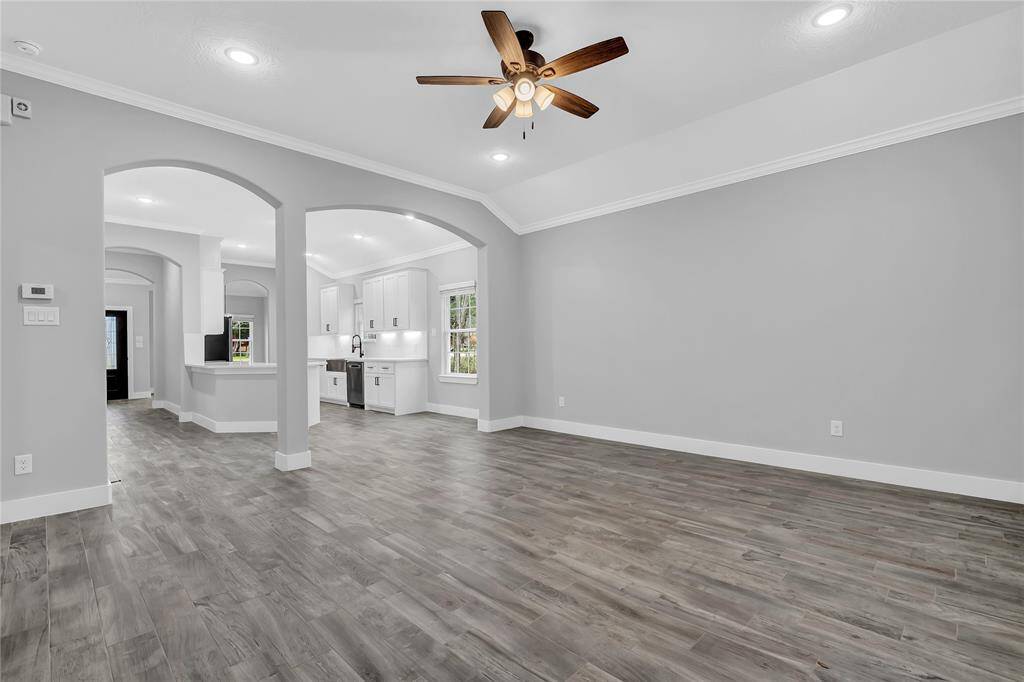 Spacious living area is open to the kitchen. High ceilings and crown molding are found throughout the living, dining, kitchen and entry.