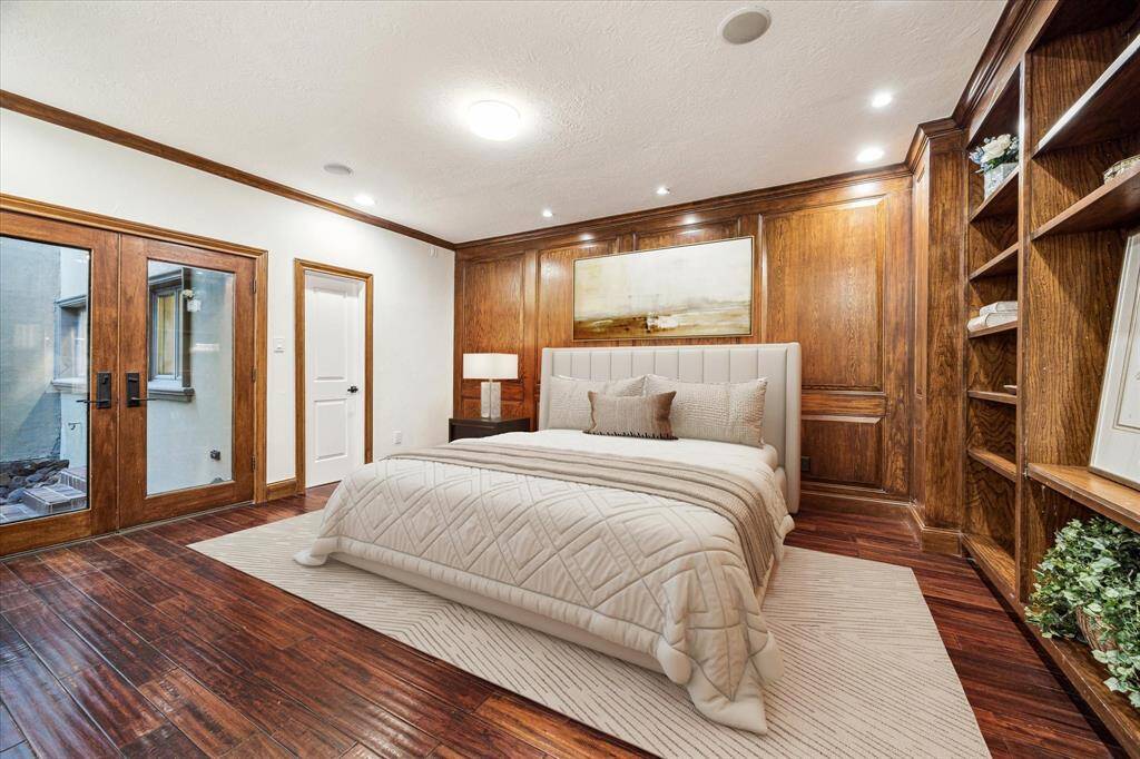 FIRST FLOOR GUEST SUITE… Virtually Staged Private Guest Suite has hardwood flooring, built-in adjustable shelving, and exquisite paneled walls. Full ensuite bathroom and kitchenette with pool views.