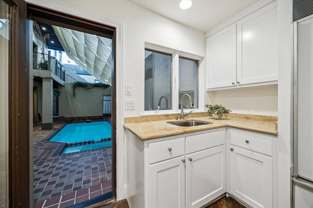 KITCHENETTE… Tile flooring, marble counters, built-in cabinetry, stainless undermount sink, and full-size subzero fridge. Door to pool/spa area makes this perfect for pool-side cooking.