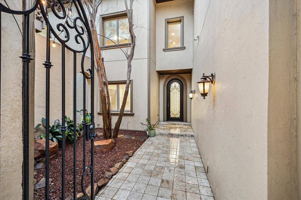 WELCOME HOME... A custom wrought iron gate, interior courtyard with moss-rock landscaping and chiseled travertine walkway all draw the eye upon the entry. The exterior stucco is over brick, which is far superior in durability and performance to stucco over wood.