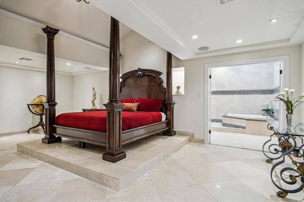 PRIMARY RETREAT… Dramatic view of the primary suite shows a French door entry that leads into the stunning spa-like bath.