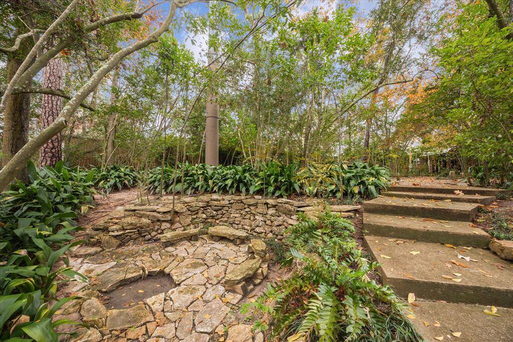 The backyard has winding stone pathways, and this area for seating surrounded by lush greenery.