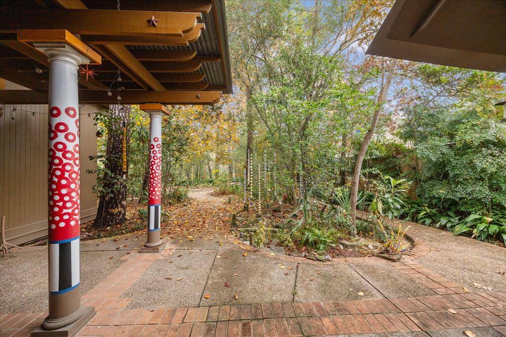 The back patio features brick pavers, a great area to enjoy the outdoors and the shade from the trees.