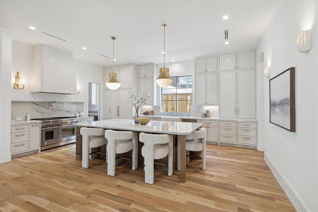 The Kitchen boasts amazing light fixtures, a custom stained island, a vent-hood with plaster finish, a pot filler and high end appliances by Thermador. Built in Refrigerator included. Refrigerator, wine chiller and dishwasher are paneled. Custom site-built cabinets with soft closing mechanism.