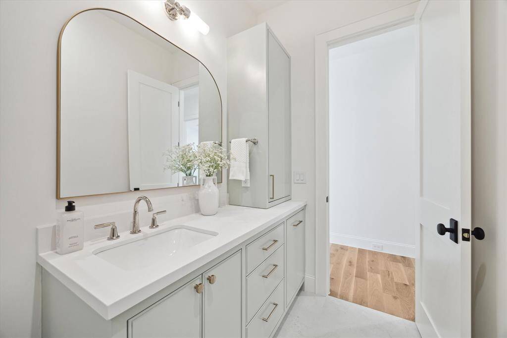 Bath 2 featuring delta plumbing fixtures, decorative mirror and beautiful stie built cabinetry with linen and hamper.
