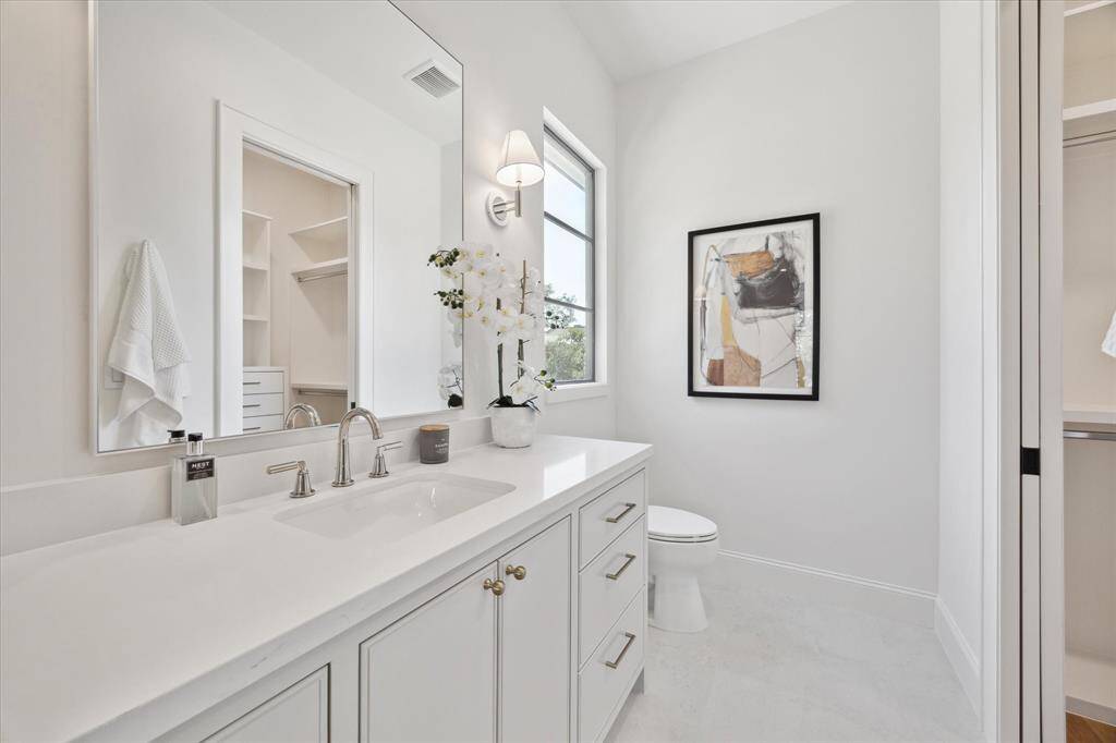 Bath 4 with two sconces, decorative mirrors and site built cabinets.