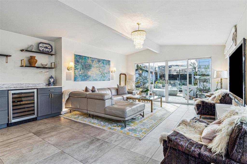 The oversized family room features a dry bar, two walls of windows, and access to the beautiful backyard through double sliding glass doors.