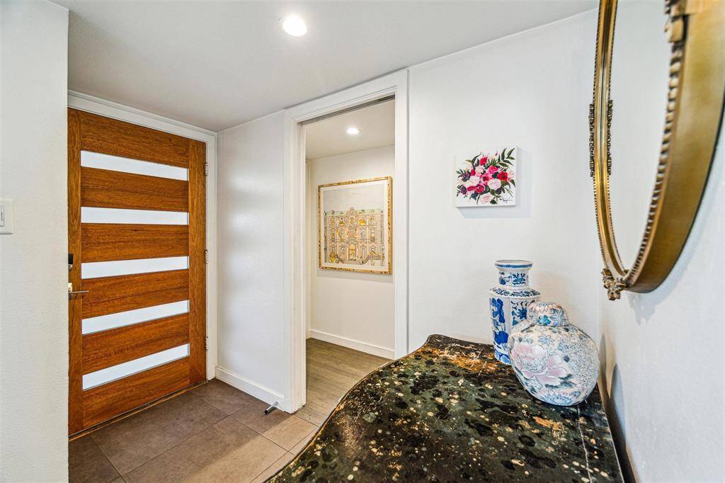 Formal entry with solid wood, frosted glass pane front door.