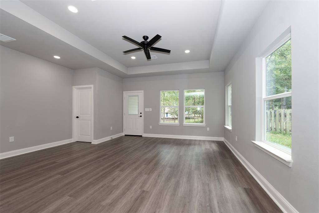 This open-concept living room is bright and spacious, with plenty of windows that fill the space with natural light. The expansive layout creates a welcoming atmosphere, perfect for both relaxation and entertaining. With its comfortable design and connection to the rest of the home, this living room is a warm and inviting space to enjoy every day.