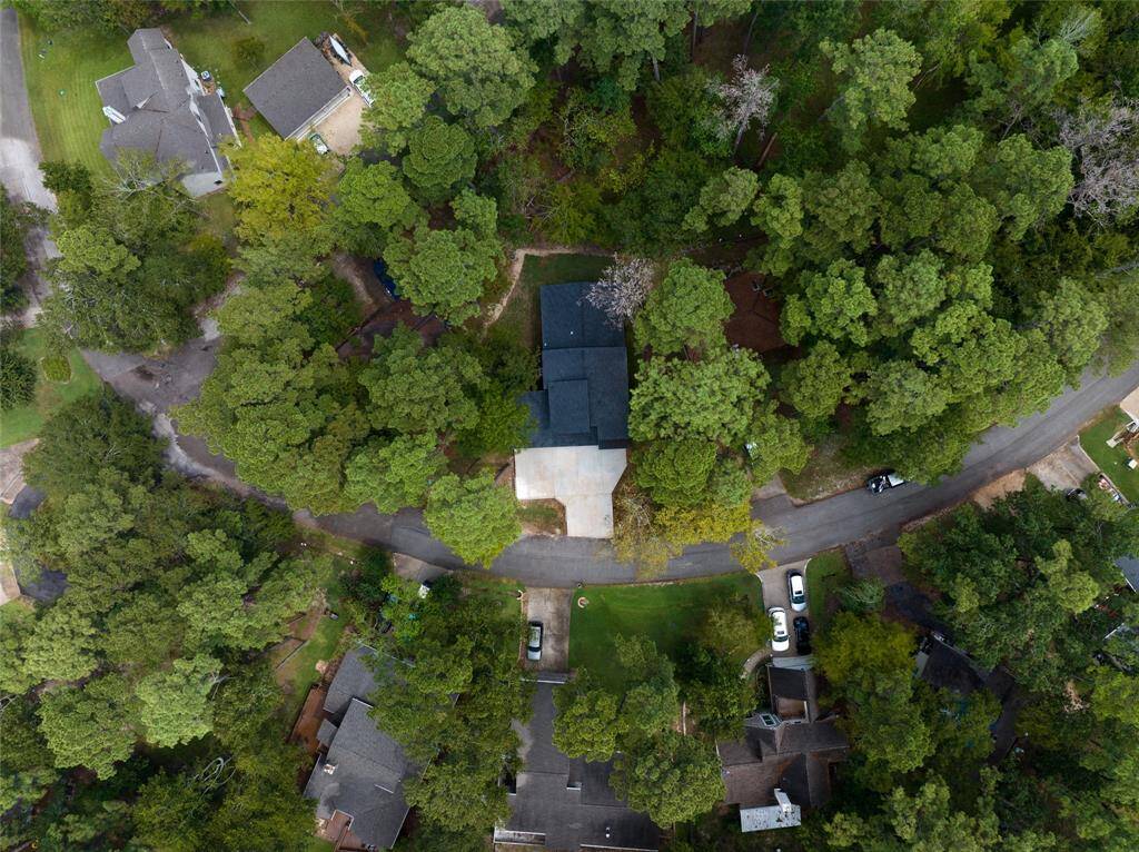 This aerial view highlights a peaceful lakeside community nestled within a lush, forested area. The waterfront properties, complete with private docks, offer a tranquil and private living environment with direct access to the water, making it the perfect place to call home.