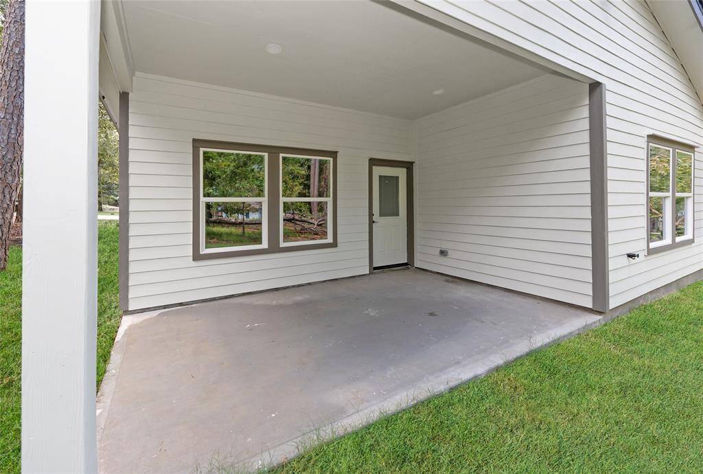 The back patio offers a serene outdoor space with a beautiful view of the wooded area, perfect for relaxing or entertaining. Surrounded by nature, it provides a peaceful retreat to enjoy the sights and sounds of the outdoors.
