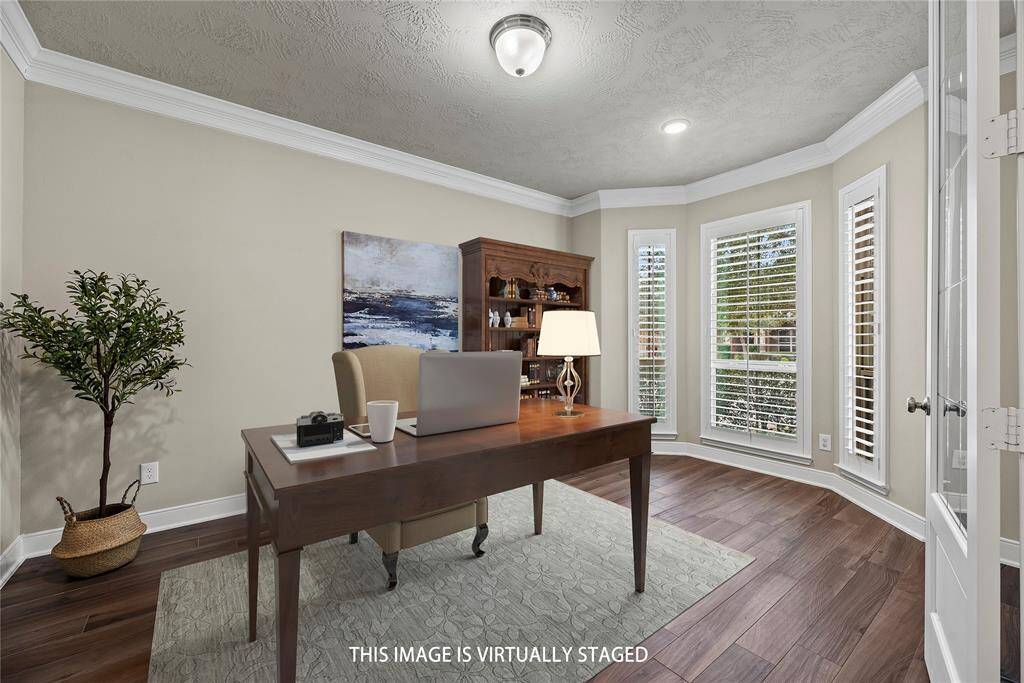 Generously sized office with French doors, crown molding, and plenty of natural light, creating an inviting and productive space.