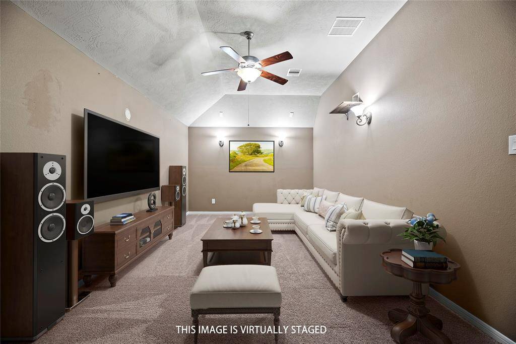 Get the popcorn, it’s movie time! This fabulous home theater is ready for action with plush carpet, custom paint and a raised ceiling with recessed lights and a ceiling fan.