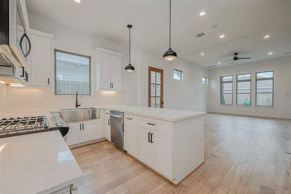 Modern shaker style cabinets with quartz countertops and pendant lighting.