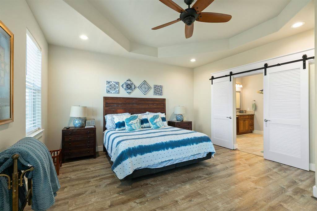 Primary Suite features a tray ceiling & recessed lighting along with stylish sliding doors.