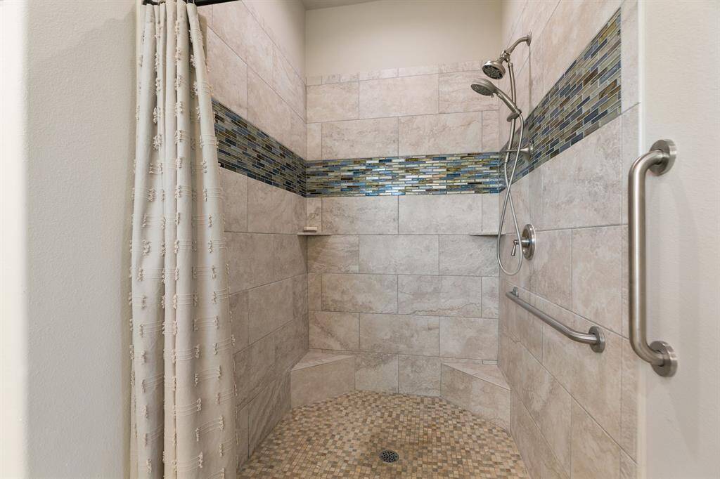 Walk-in shower in primary bath includes duel shower heads.