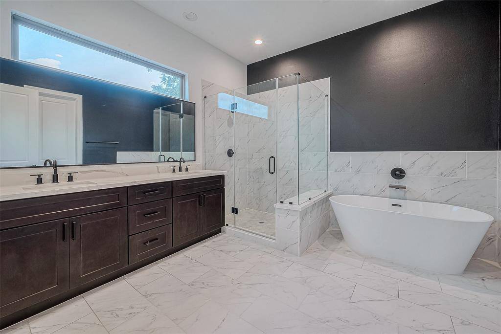 Huge primary bathroom with double sinks, separate shower and tub.