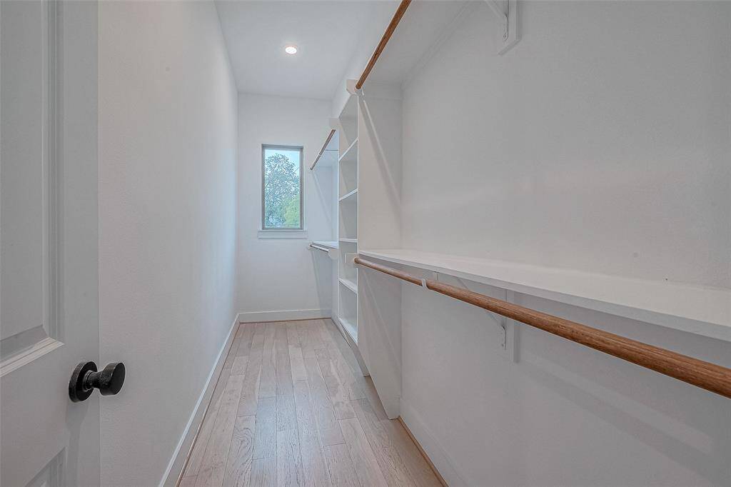 Generous size primary closet with a window.