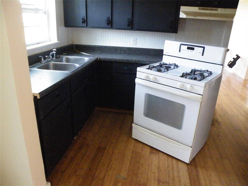 Kitchen with gas stove (it is pulled from the wall to show the gas connection