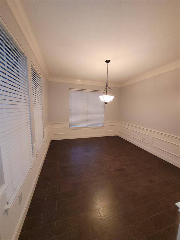 To the left of the foyer, through a hallway is this large dining room with wainscoting on the walls. This room has been recently painted a neutral color.