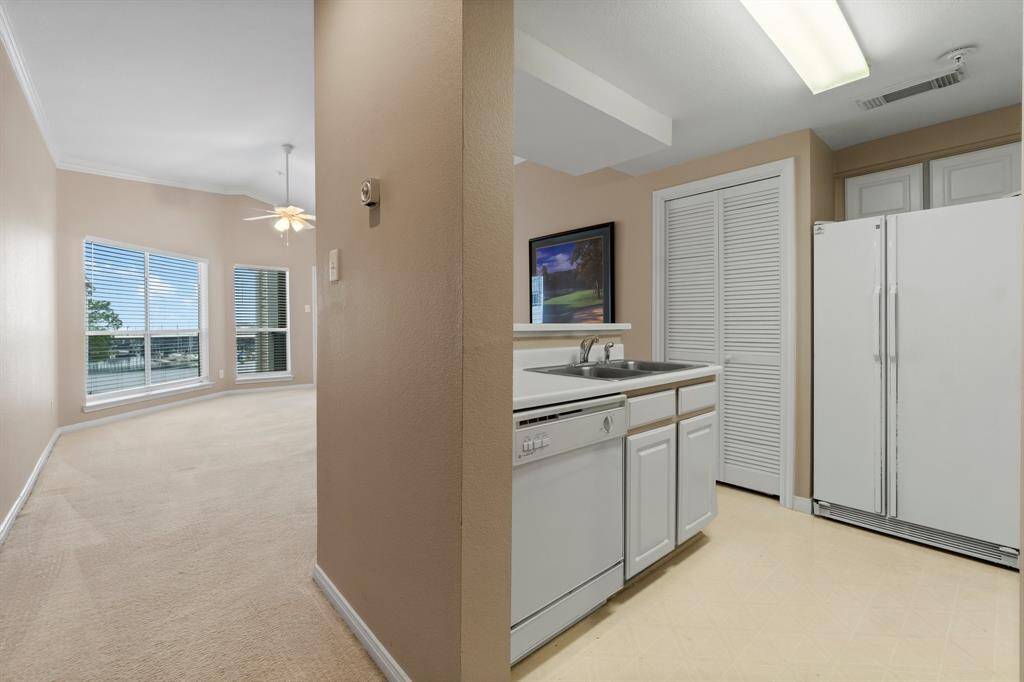 showcasing a bright kitchen and dining area. The kitchen features white cabinetry, a dishwasher, and a double-door refrigerator.
