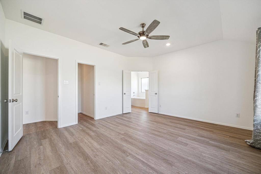 View in the primary bedroom showing the full entrance to the primary bath and to the second closet that connects to the laundry room