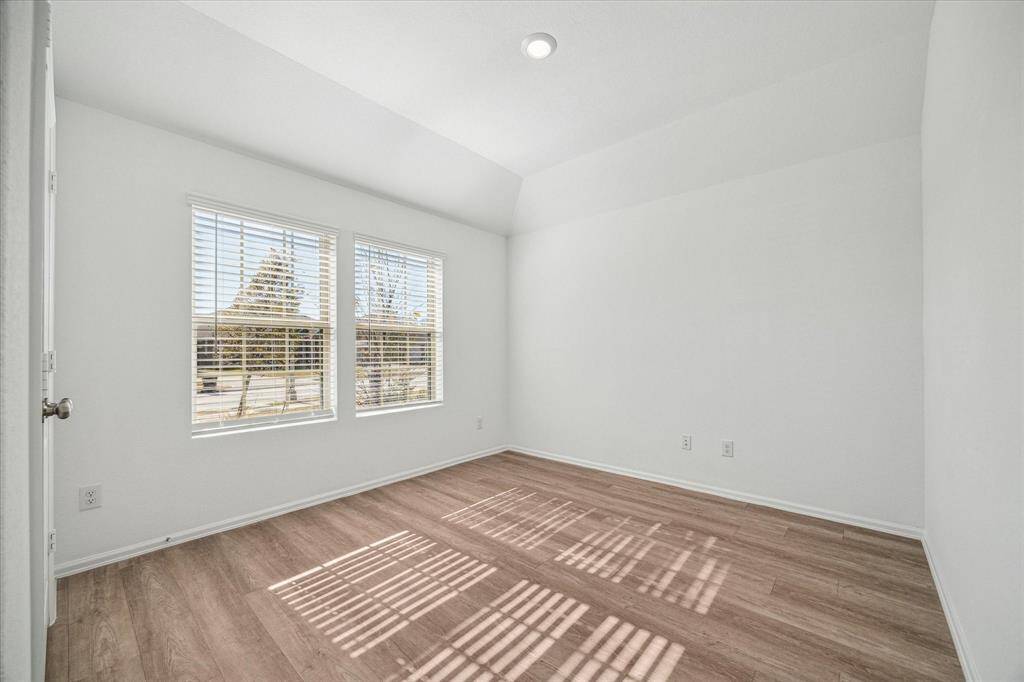 This bright room features large windows offering a versatile space perfect for a bedroom or office.