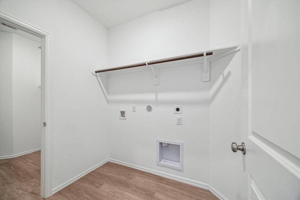 This photo shows the laundry room that has a closet to the left which connects to the primary bedroom