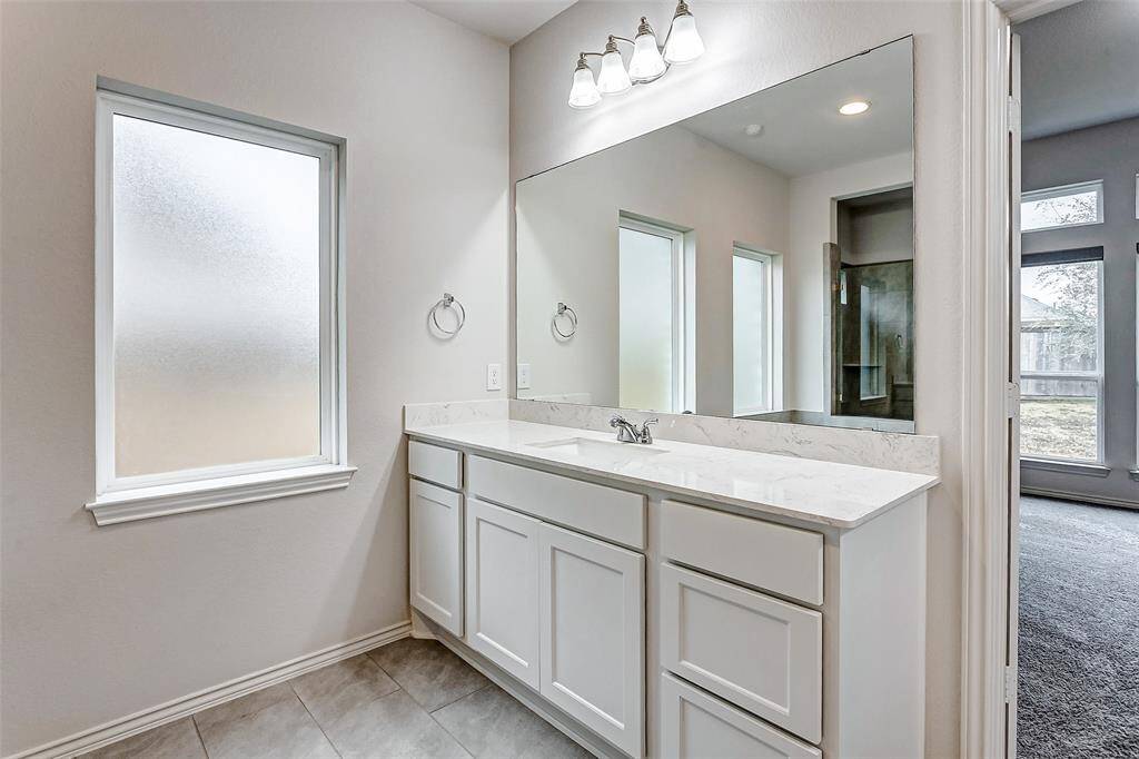 Frosted windows provide ample natural light while maintaining privacy. The neutral tile flooring complements the clean, contemporary design.
