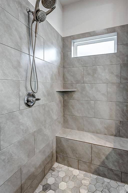 Shower offer built-in bench, and a high window for natural light. The hexagonal floor tiles add a stylish touch.