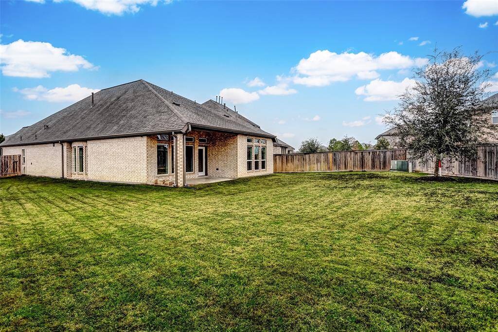 Well-maintained lawn and small tree for natural shade. Covered patio area, ideal for outdoor activities and entertainment.