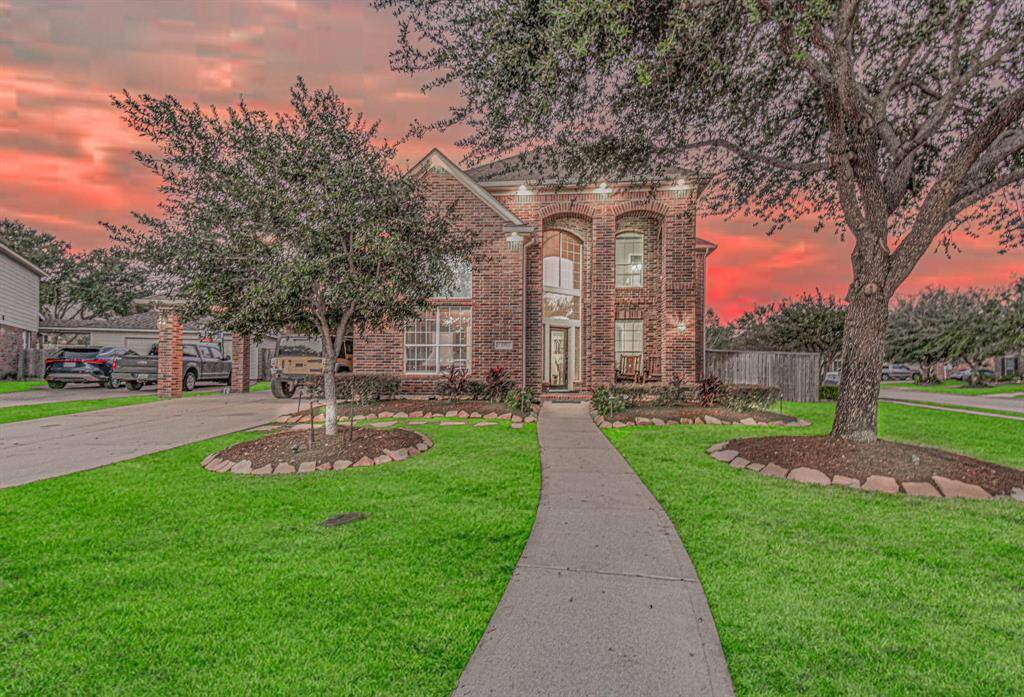 Elegant brick façade with lush landscaping enhances the home's captivating curb appeal.