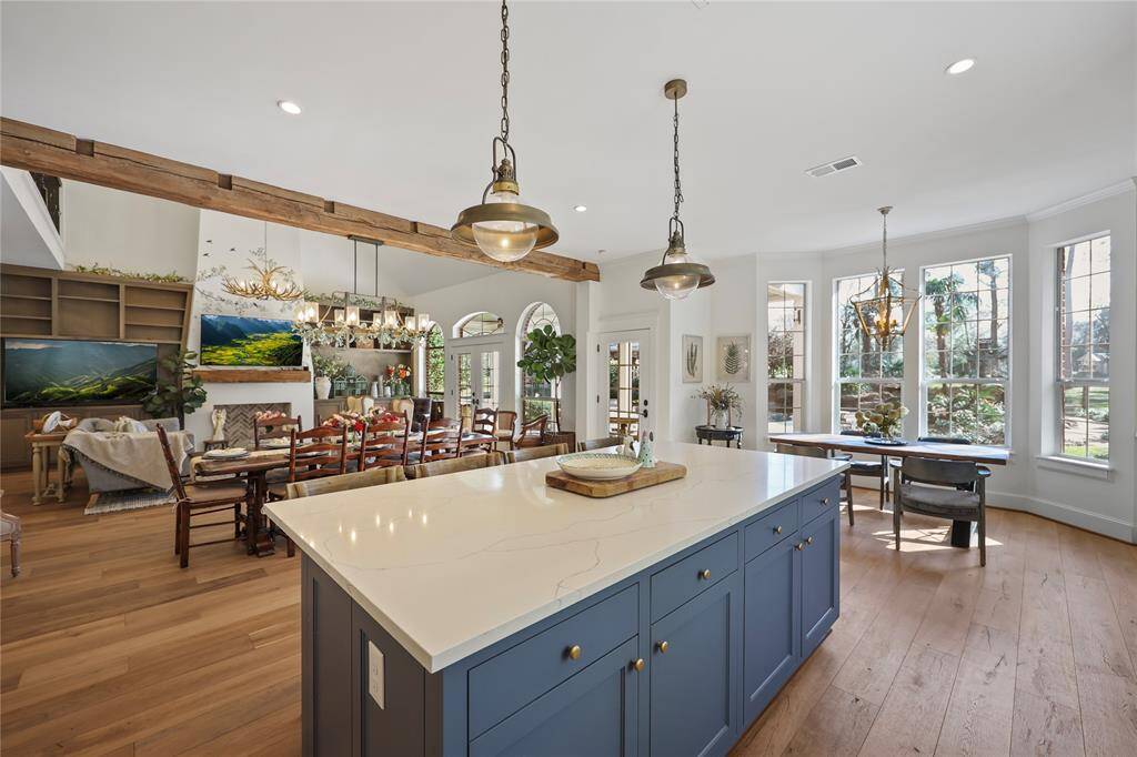 The lighting in this space was thoughtfully chosen to enhance the overall aesthetic of the open-concept kitchen, dining, and living area.