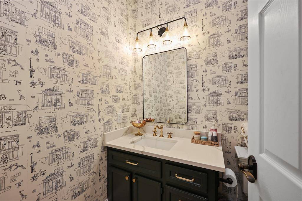 Secondary bathroom with a single sink vanity and modern mirror and light fixture.