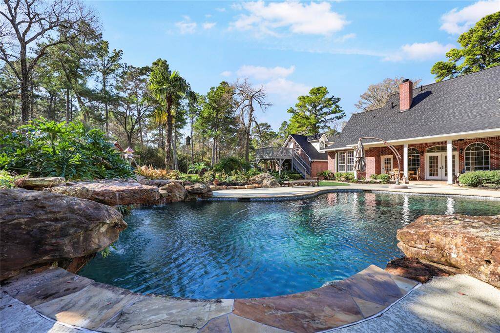 A breathtaking backyard oasis featuring a resort-style pool with cascading waterfalls