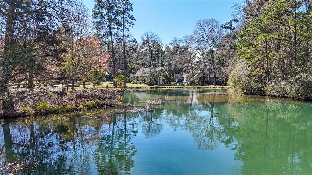 Serene views of the large stocked pond with views of the estate in the background, the wood bridge that is over the pond was added in January 2024.
