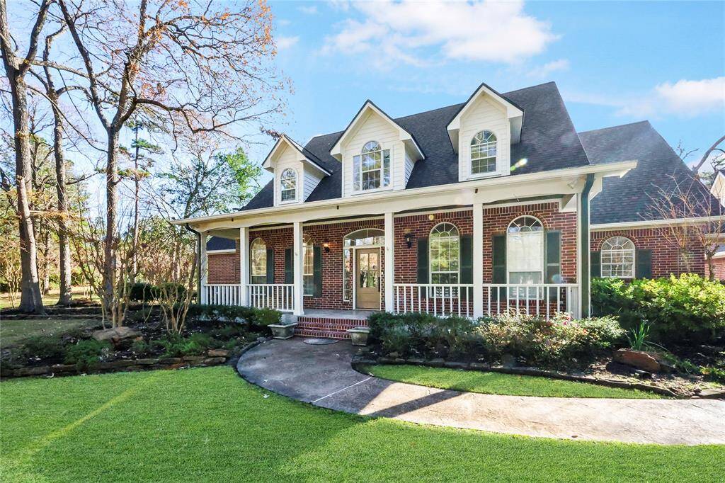 The curved concrete walkway, lush green grass, neatly trimmed bushes, and a garden bed with rocks and plants lead you to the beautiful two-story brick home. The exterior was repainted in February 2024.