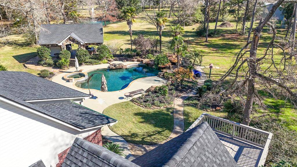The expansive property is beautifully manicured and features a pond and mature trees